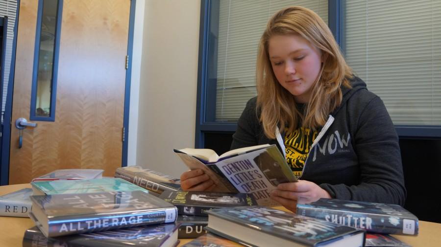Senior Emmaline Harris, president of the Bruin Book Club reads several books and helps choose the best ones for Teen Read Week.
