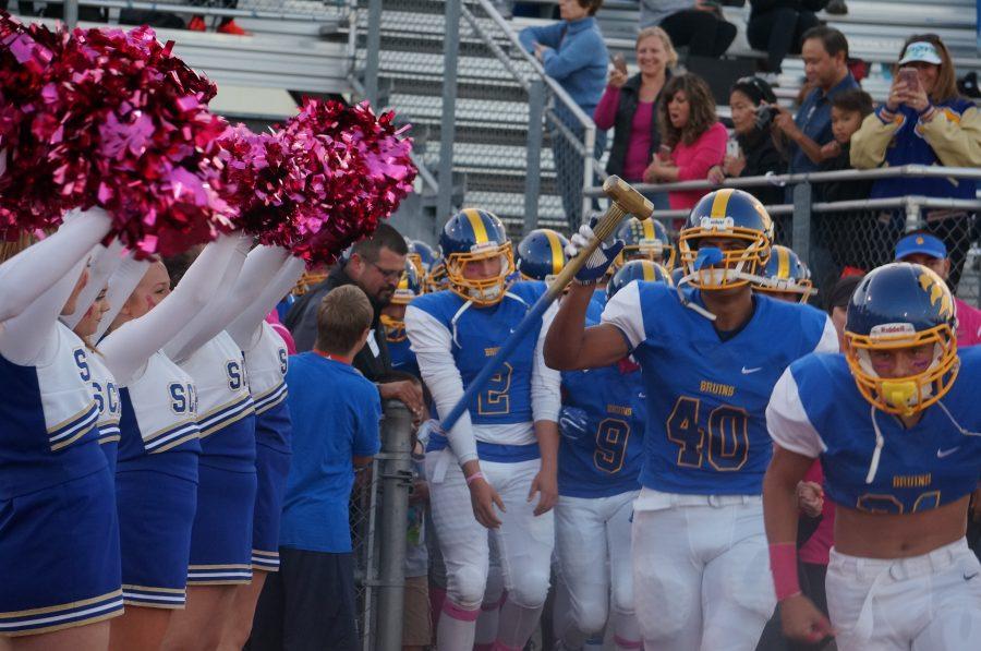 The+football+team+and+the+cheerleaders+wore+pink+accents+to+show+their+support+for+the+cancer+survivors.+