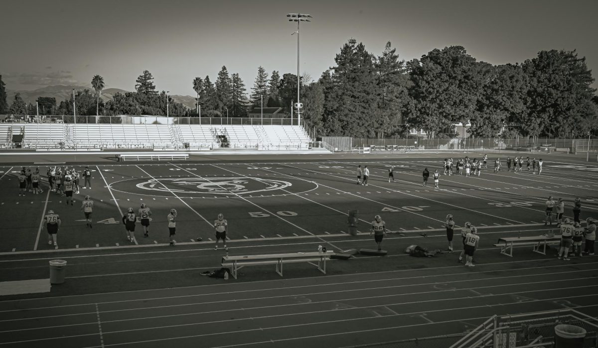 JV and Varsity football teams share time on the main field while other sports teams practice on the back fields.