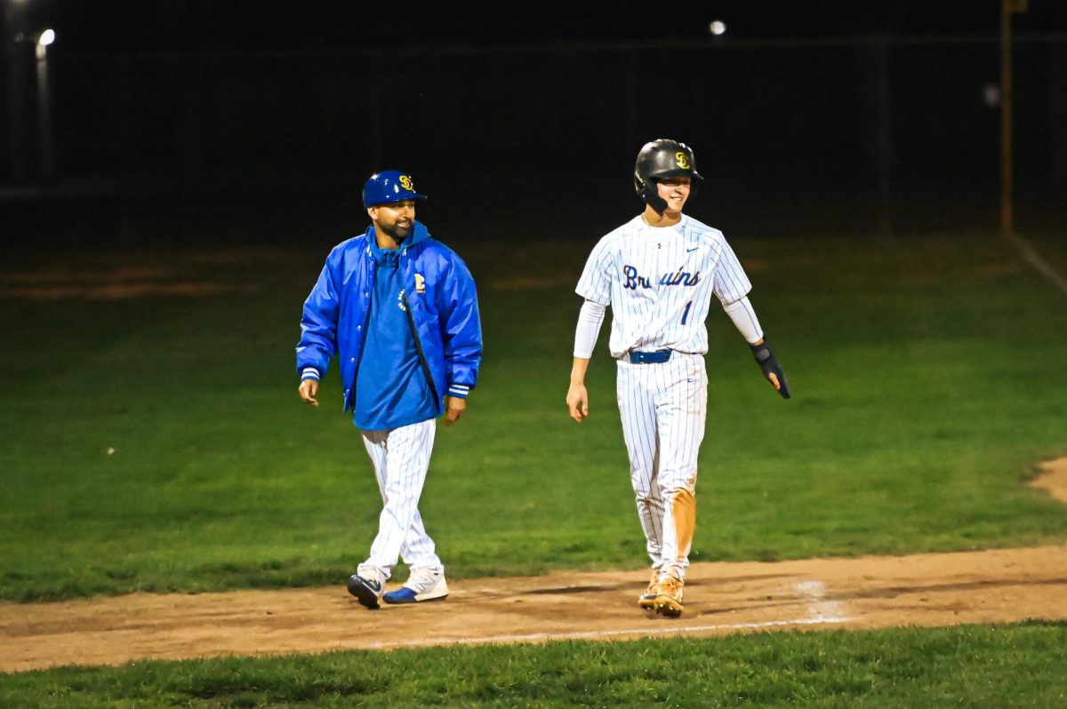 Varsity baseball coach Pedro Martinez (left) and senior Andrew Traffas (right) are learning to adjust to some of the new rules in high school baseball, although they are different from the MLB.