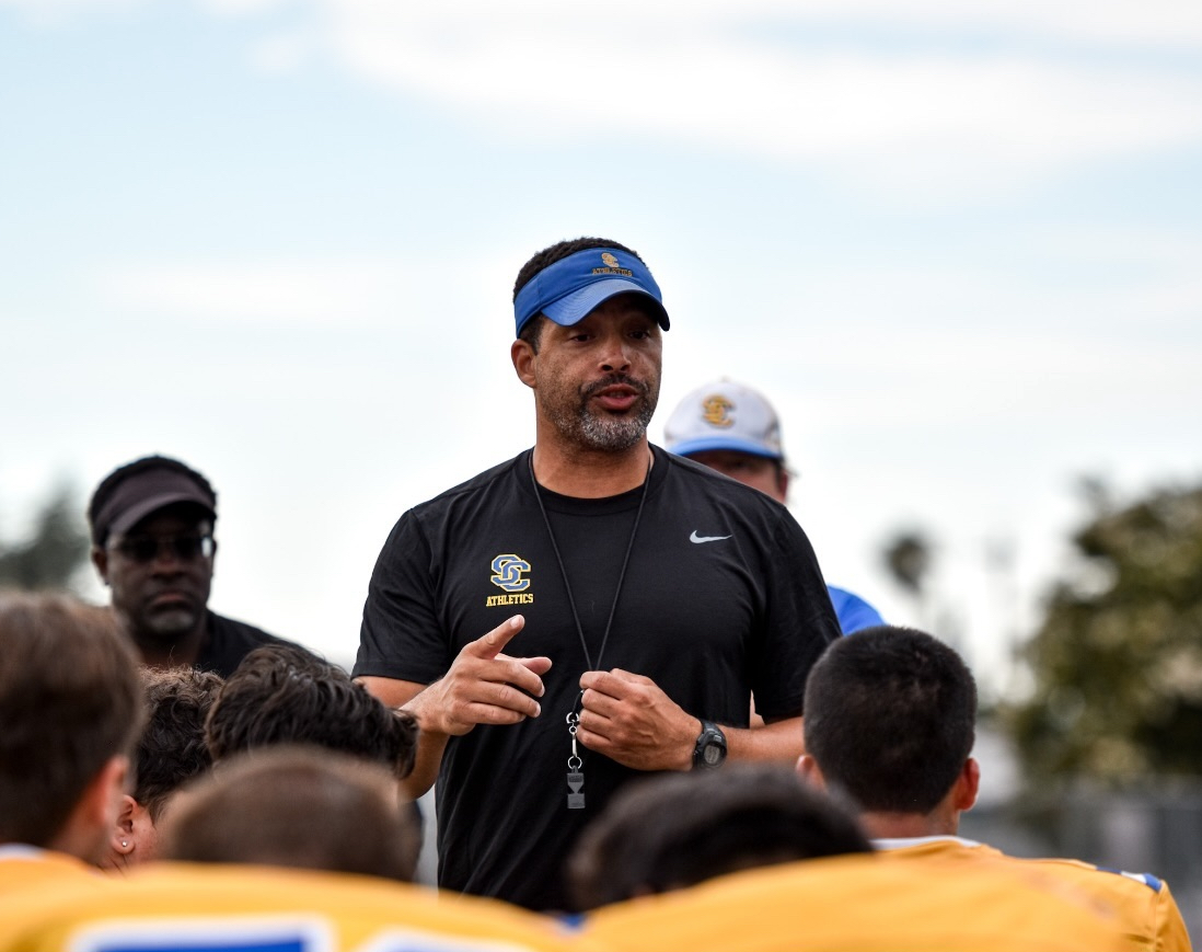 Head football coach Nelson Gifford instructs football players during spring training, preparing them for summer practices.